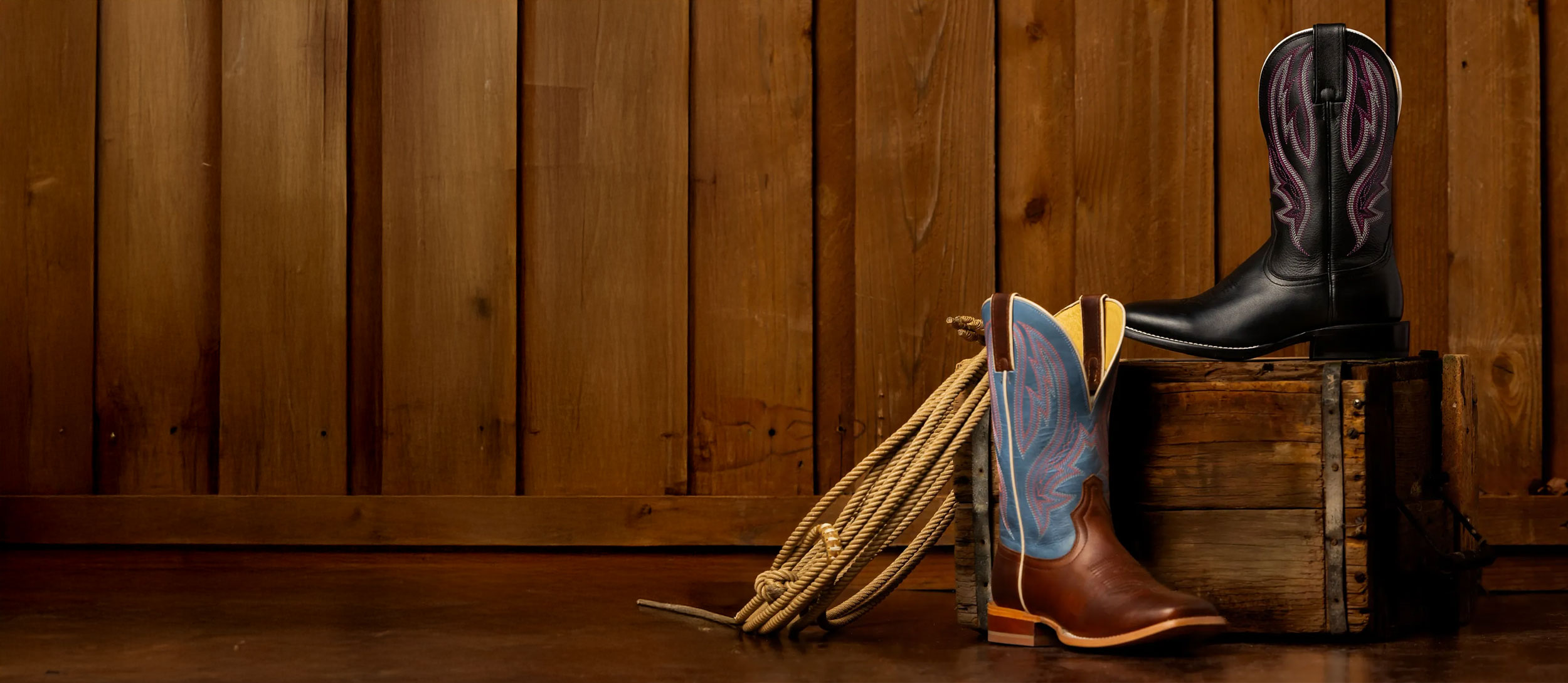 A half pair of Darcia 11” Western boots in brown and black set up on a box.
